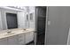 Bathroom with dual sinks, white vanity, large mirror and closet, adjacent to a bedroom at 4827 Wyndam Dr, Stone Mountain, GA 30088