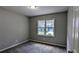 Bedroom with gray walls, gray carpet and a window overlooking the neighborhood at 4827 Wyndam Dr, Stone Mountain, GA 30088