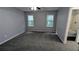 Bedroom with gray walls, gray carpet, ceiling fan and attached bathroom featuring shower and tub at 4827 Wyndam Dr, Stone Mountain, GA 30088
