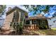 Rear exterior of home with patio, lawn, and mature trees and shrubbery at 4827 Wyndam Dr, Stone Mountain, GA 30088