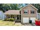 Charming two-story home featuring stone accents and red shutters, complemented by a two-car garage at 4827 Wyndam Dr, Stone Mountain, GA 30088