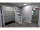 Hallway features gray walls, gray carpet, laundry closet and access to stairs at 4827 Wyndam Dr, Stone Mountain, GA 30088