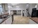 Open-concept kitchen featuring tile flooring, white cabinets, and a view of the cozy living area at 4827 Wyndam Dr, Stone Mountain, GA 30088
