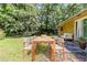 Outdoor patio with a wooden dining table set, a lounge bench, and a lush green lawn at 5509 Covent Way, Lithonia, GA 30058