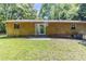 Spacious backyard featuring a sliding glass door, small patio, and lush lawn at 5509 Covent Way, Lithonia, GA 30058