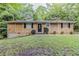 Charming single story home featuring a well-kept lawn, trimmed shrubs, and a unique stone facade at 5509 Covent Way, Lithonia, GA 30058