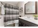Well-lit bathroom has a single vanity, framed mirror, and shower with decorative curtain at 1972 Clovercroft Rd, Acworth, GA 30101