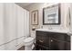 Neat bathroom features a vanity, toilet, shower with a curtain, and a framed mirror at 1972 Clovercroft Rd, Acworth, GA 30101
