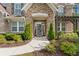 Charming entrance with decorative door, stone accents, complemented by a lush garden at 1972 Clovercroft Rd, Acworth, GA 30101