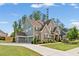 Well-maintained home featuring three-car garage, lush lawn, and complemented by mature trees and landscaping at 1972 Clovercroft Rd, Acworth, GA 30101