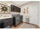Functional laundry room with washer, dryer, sink, storage cabinets, and decorative accents at 1972 Clovercroft Rd, Acworth, GA 30101