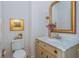 This bathroom features patterned wallpaper, toilet, and vanity sink with marble countertop and gold-framed mirror at 341 Lands Se Ml, Marietta, GA 30067