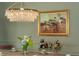 Close-up of a crystal chandelier illuminating a dining room with bar cart and flowers at 341 Lands Se Ml, Marietta, GA 30067