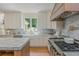 This kitchen has stainless steel appliances, gorgeous marble countertops, white cabinets, and hardwood floors at 341 Lands Se Ml, Marietta, GA 30067
