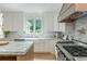Well-lit kitchen with marble backsplash, a farmhouse sink, and stainless steel appliances at 341 Lands Se Ml, Marietta, GA 30067