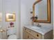A charming powder room featuring decorative wallpaper, marble vanity and brass fixtures at 341 Lands Se Ml, Marietta, GA 30067