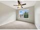 Well-lit bedroom with neutral carpet, a ceiling fan, and a large window at 617 Kyles Cir, Hiram, GA 30141