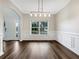 Elegant dining room featuring hardwood floors, wainscoting, and modern chandelier at 617 Kyles Cir, Hiram, GA 30141