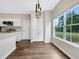 Bright eat-in kitchen featuring wood floors, white cabinets, stainless appliances, and a modern light fixture at 617 Kyles Cir, Hiram, GA 30141
