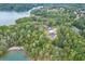 Aerial view of a home surrounded by a dense forest near a lake with docks at 7620 Breeze Bay Rd, Cumming, GA 30041