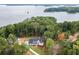 Aerial view of a home surrounded by lush greenery and situated near a lake at 7620 Breeze Bay Rd, Cumming, GA 30041