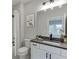 Modern bathroom features a white vanity with black countertop and decorative print wall art at 7620 Breeze Bay Rd, Cumming, GA 30041