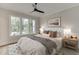 Comfortable bedroom with neutral tones, large windows, a tufted headboard, and hardwood floors at 7620 Breeze Bay Rd, Cumming, GA 30041