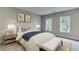 Cozy bedroom with two windows, nightstands, and a comfy bed covered with pillows and blankets at 7620 Breeze Bay Rd, Cumming, GA 30041