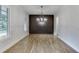 Bright dining room with hardwood floors, wainscotting, and modern chandelier for elegant dining at 7620 Breeze Bay Rd, Cumming, GA 30041