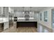 Modern kitchen features white cabinets, large island, stainless steel appliances and hardwood floors at 7620 Breeze Bay Rd, Cumming, GA 30041
