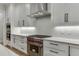 Modern kitchen featuring white cabinets, stone countertops, stainless steel oven, and diamond pattern backsplash at 7620 Breeze Bay Rd, Cumming, GA 30041
