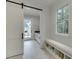Charming mudroom with shiplap walls, a sliding barn door, bench seating, and storage at 7620 Breeze Bay Rd, Cumming, GA 30041