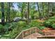 Backyard with a wooden deck and stairs descending into a lush, green landscape at 88 Karland Nw Dr, Atlanta, GA 30305