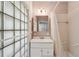 Compact bathroom showcasing a glass block window, vanity, and combined tub shower at 88 Karland Nw Dr, Atlanta, GA 30305