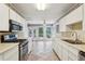 Bright kitchen boasts tiled floors, stainless steel appliances, and a sunroom with outside views at 88 Karland Nw Dr, Atlanta, GA 30305