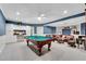 Finished basement with stylish blue walls, a pool table, and built-in shelving at 2020 Windermere Xing, Cumming, GA 30041