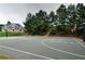 Community basketball court with a home in the background surrounded by mature trees at 2020 Windermere Xing, Cumming, GA 30041