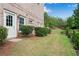Home exterior with manicured landscaping and door leading to backyard at 2020 Windermere Xing, Cumming, GA 30041