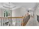 Upstairs hallway with decorative railings leads to bedrooms, features a trey ceiling with large windows at 2020 Windermere Xing, Cumming, GA 30041
