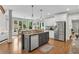 Open concept kitchen features granite countertops, stainless steel appliances, and breakfast bar at 2020 Windermere Xing, Cumming, GA 30041