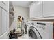 Functional laundry room features a large washer and dryer, storage cabinets, and shelving at 2020 Windermere Xing, Cumming, GA 30041