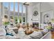 Bright living room features high ceilings, large windows, and a cozy fireplace with detailed mantle at 2020 Windermere Xing, Cumming, GA 30041