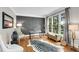 Cozy living room with hardwood floors, decorative rug, and large windows offering natural light and serene views at 2020 Windermere Xing, Cumming, GA 30041
