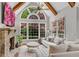 Bright living room features a stone fireplace, large windows, and vaulted ceiling with wooden beams at 2020 Windermere Xing, Cumming, GA 30041