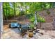 Back patio features seating with cushions, lush foliage and trees in the background at 525 Watergate Ct, Roswell, GA 30076