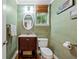Stylish powder room with green wallpaper, decorative mirror, sink, toilet, and window at 525 Watergate Ct, Roswell, GA 30076