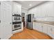 Well-lit kitchen with stainless appliances, white cabinetry, and granite counters providing ample storage at 525 Watergate Ct, Roswell, GA 30076
