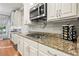Gourmet kitchen boasts granite counters, a gas cooktop, and white cabinets, perfect for cooking at 525 Watergate Ct, Roswell, GA 30076