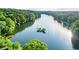 Scenic aerial view of the lake surrounded by lush green trees and foliage at 525 Watergate Ct, Roswell, GA 30076