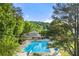 Aerial view of a community pool surrounded by lush trees and manicured landscaping at 525 Watergate Ct, Roswell, GA 30076